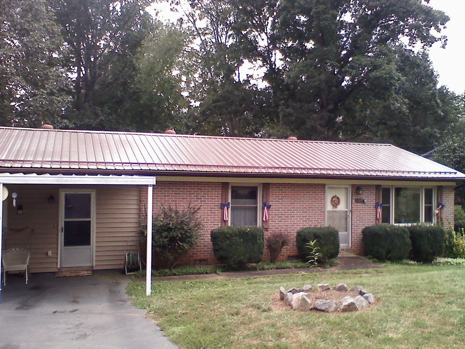 Bronze metal roof and carport on a brick ranch home — Roof Repair work by our crew in Sylvania
